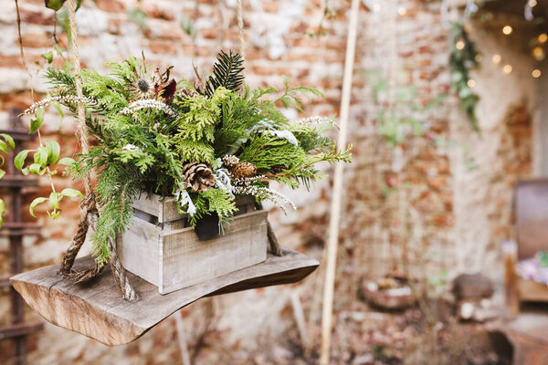 Natural DIY outdoor Christmas decoration in garden. Pine branches and pine cones in box. Environment, recycle, reuse and zero waste concept. Selective focus, focus space