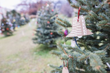 Açık havada, Noel ağacında el yapımı kahverengi karton kağıt Noel çanı süslemesi. Çocuklar için ölüm. Çevre, geri dönüşüm, yeniden kullanım, yükseltme, sıfır atık kavramı. Seçici odak, kar arkaplanı yok