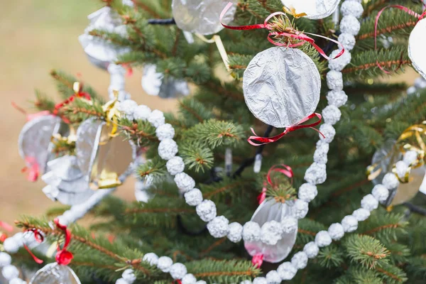 户外圣诞树上的铝箔手工装饰 为孩子们提供创造性的想法 循环利用 循环利用和零废物概念 有选择的重点 — 图库照片
