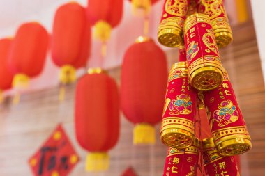 Celebration of Chinese Lunar New Year concept. Traditional Chinese red and gold decoration and firecrackers hang. Protection and security of home in new year. Selective focus, copy space