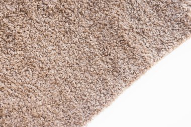 New soft brown curly teddy fleece plush throw blanket or pillow case on white background. Abstract fabric texture background with curles. Top view, closeup