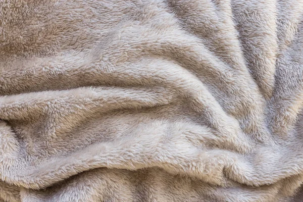 New soft brown throw blanket with waves. Abstract fabric texture background with waves. Top view, close up