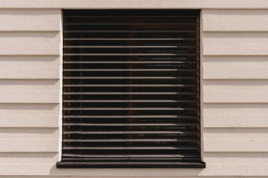 Bej desenli duvarda Yatay Panjurlu Modern Pencere.