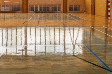 Cilalı basketbol sahası ve çoklu spor sahaları olan boş bir spor salonu..