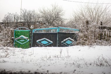 Karla kaplı eski ahşap kapı.