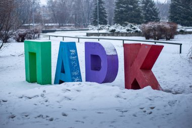 Çocuk parkına girmeden önce karla kaplı büyük renkli mektuplar.