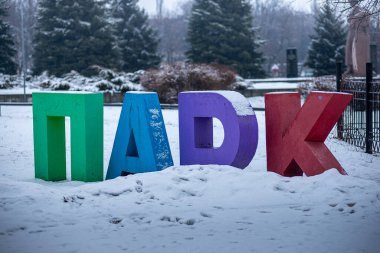 Çocuk parkına girmeden önce karla kaplı büyük renkli mektuplar.