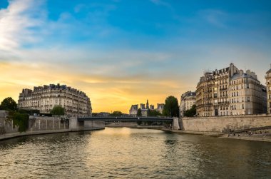 Paris 'te cam pencereleri ve balkonları olan yaşlanmış gri bir konut binasının dışı..