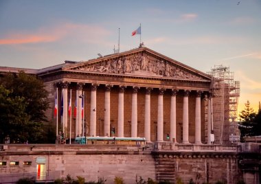 Paris 'te cam pencereleri ve balkonları olan yaşlanmış gri bir konut binasının dışı..