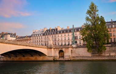 Paris 'te cam pencereleri ve balkonları olan yaşlanmış gri bir konut binasının dışı..