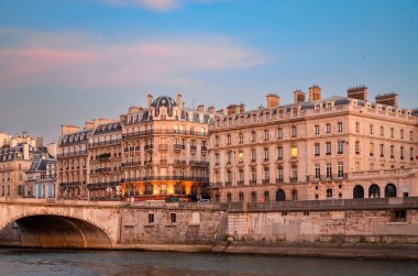 Paris 'te cam pencereleri ve balkonları olan yaşlanmış gri bir konut binasının dışı..
