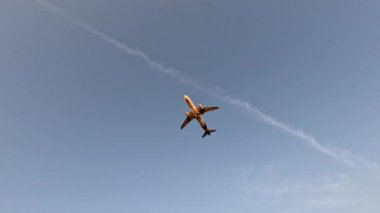 Uçak gün batımında denizin üzerinden havalanıyor.