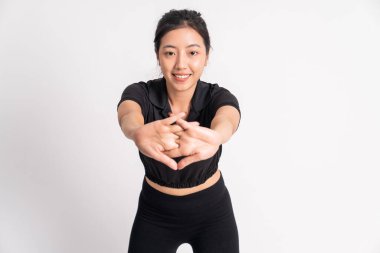 Siyah spor kıyafetleri giyen bir kadının arka planda uzanan elleri izole edilmiş.