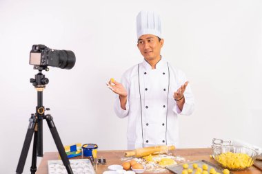 Asyalı erkek aşçı yemek pişirme videosu hazırlıyor.