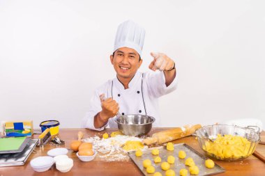 Mangırı izole edilmiş arka planda karıştırırken kamerayı işaret eden hareket eden erkek şef.