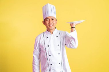 Yakışıklı erkek şef servis tabağını izole edilmiş arka planda duruyor.
