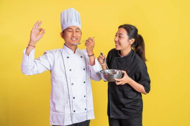 Şef yemek tadıyor, el hareketleriyle kadın aşçıyla münzevi bir geçmişi var.