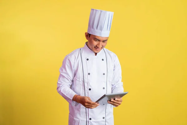 male chef wearing chef jacket using a pad on isolated background