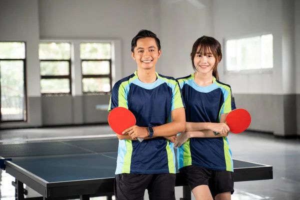 Двоє Усміхнених Азіатських Спортсменів Тримають Весла Стоячи Перед Столом Пінг — стокове фото