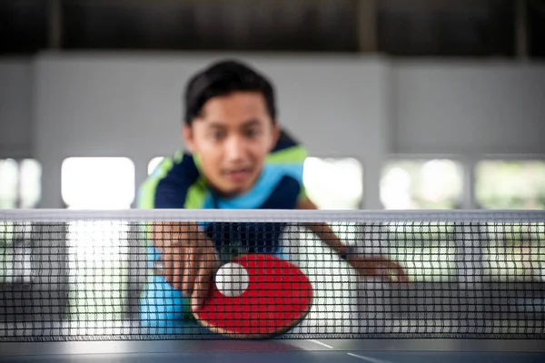 乒乓球比赛中 一名男选手在接近网时用桨击球 — 图库照片