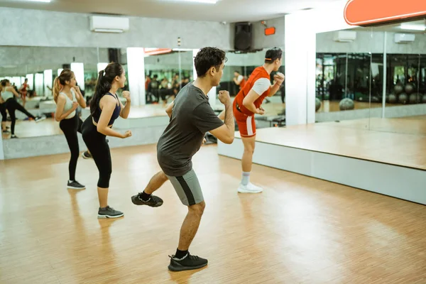 Instruktor Provádí Cvičení Stehenní Svaly Sportovní Skupinou Před Zrcadlem Fitness — Stock fotografie