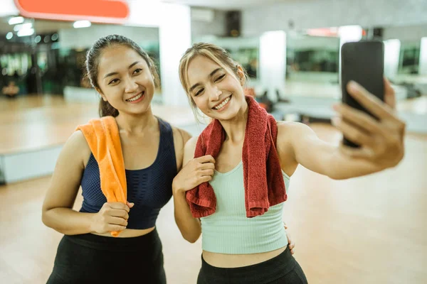 Two Sporty Women Smiling While Taking Selfie Together Using Smartphone —  Fotos de Stock