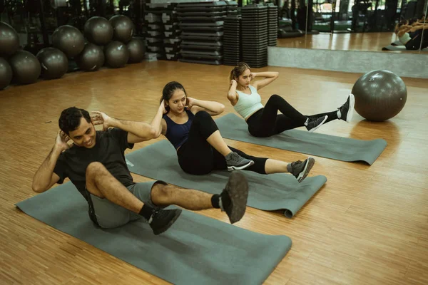 Group Sporty Young People Doing Bicycle Crunches Mats Exercise Room — Foto Stock