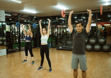 Genç spor grubu spor salonunda ağırlık kaldırıyor.