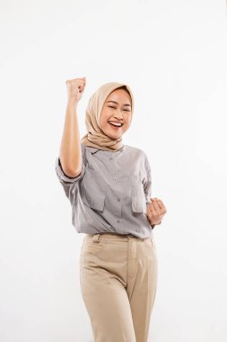 a beautiful woman with hijab standing cross legged and excitedly clenched her arms on the white background