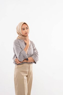 a beautiful woman with hijab standing with sullen face and touch her chin on the white background