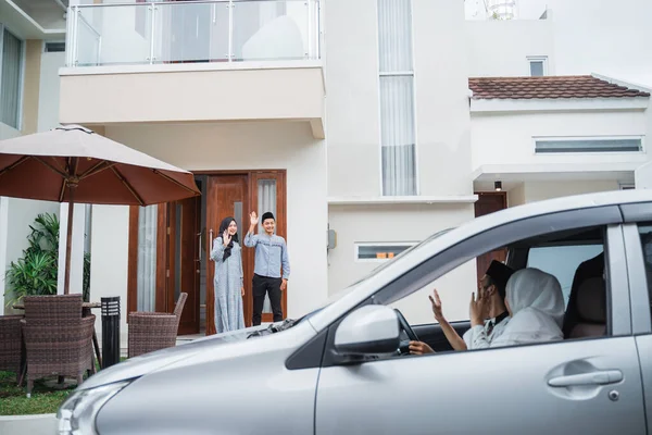 亚洲穆斯林丈夫和妻子挥手致意 欢迎乘车回家的客人 — 图库照片