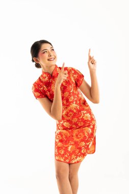 Kırmızı Cheongsam 'lı genç bir Asyalı kadın yüzünde bir gülümsemeyle bacak bacak üstüne atmış ve onu işaret etti.