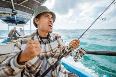 an anglers happy expression when the hook is eaten by a fish while fishing at sea