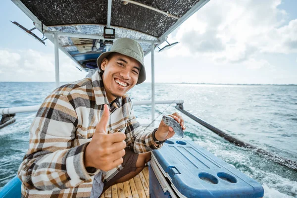 Happy Angler Thumbs While Holding Small Fish While Sea Fishing — Stockfoto