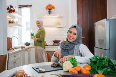 beautiful muslim woman cooking for dinner at friends home during ramadan
