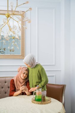 Muslim woman in hijab has a problematic friend at home