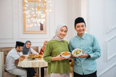 ramazan boyunca birlikte oruç kırmak için arkadaş ve aile için yiyecek sunan karı koca portresi
