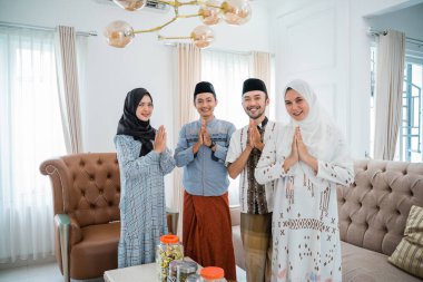 group of muslim people smiling with apologizing hand gestures during Eid