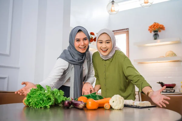 Two Women Hijabs Smile Hands Presented Table While Cooking Kitchen — Zdjęcie stockowe