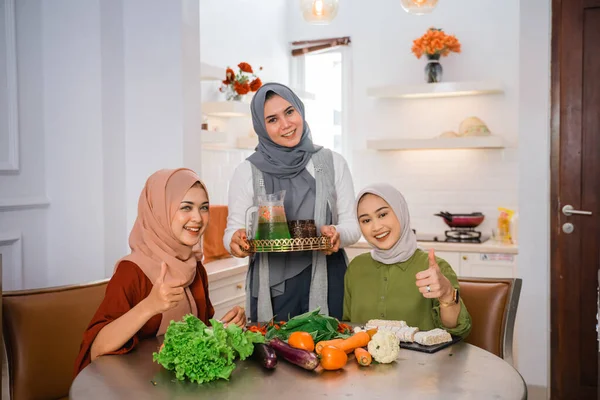 Muzułmanka Serwująca Drinka Dla Przyjaciółki Domu Podczas Gotowania Razem — Zdjęcie stockowe