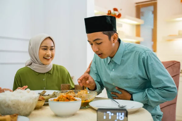husband will take food before breaking the fast with his wife sitting at the dining table