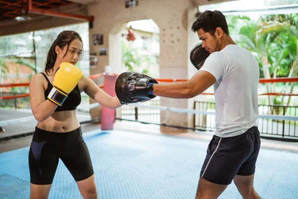 Boxeador Femenino Golpeando Almohadilla Mientras Entrena Con Entrenador Boxeo Dentro —  Fotos de Stock