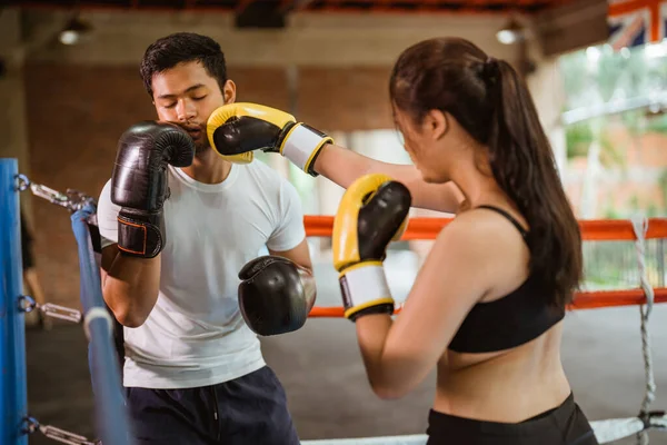 ボックスリングの中で戦っている間に頬に男性ボクサーをパンチする女性ボクサー — ストック写真