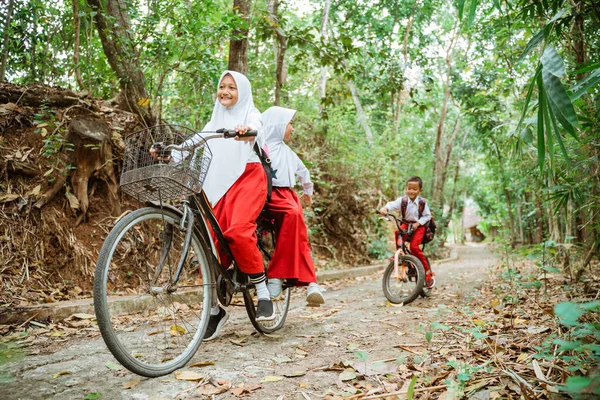 Две Красивые Девушки Школьной Форме Катаются Велосипеде Проселочной Дороге Пока — стоковое фото