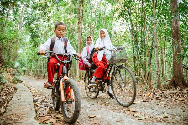 Три Ученика Начальной Школы Форме Кататься Велосипеде Вместе Школу Через — стоковое фото
