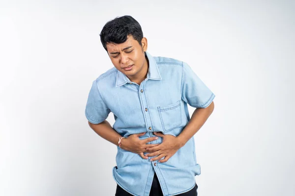 孤立背景下的亚洲年轻人胃痛时胃部疼痛的画像 — 图库照片