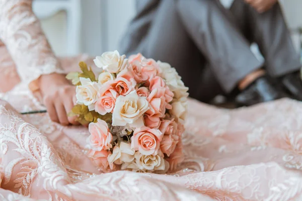 新郎新婦が床の上に腰を下ろしている花の花束 — ストック写真