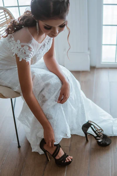 stock image asian beautiful bride in white gown wearing the black heels while sitting on the chair