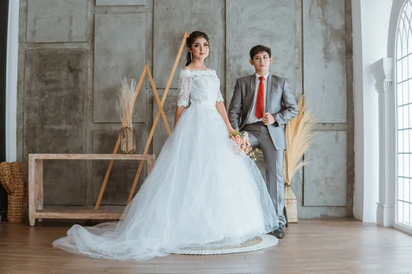 Gyönyörű Ázsiai Menyasszony Fehér Köntösben Álló Hozza Virágok Csokor Mellett — Stock Fotó