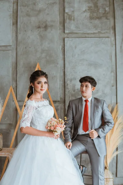Asiatisk Brudgum Röra Hans Kostym Medan Sitter Stolen Bakom Den — Stockfoto